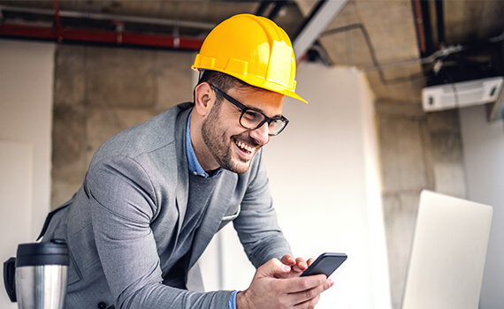 Businessman in hard hat on phone
