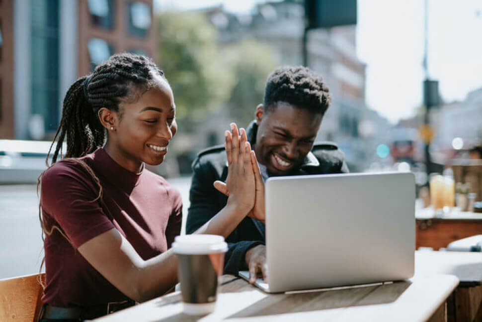Couple at computer sitting outside