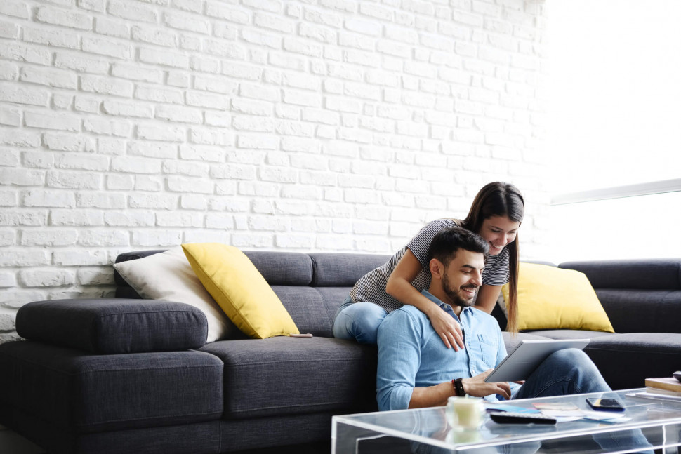 Couple on couch reading papers