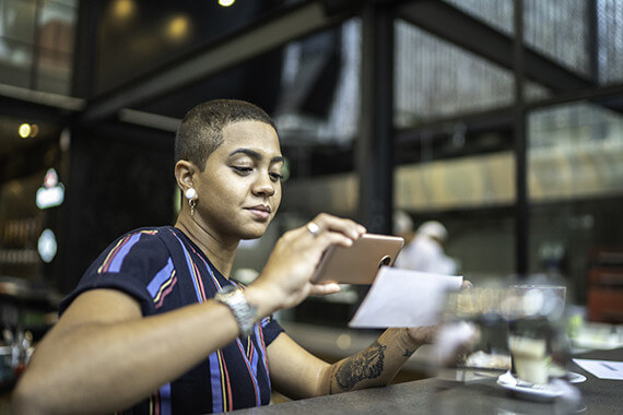 Woman holding phone taking picture of check